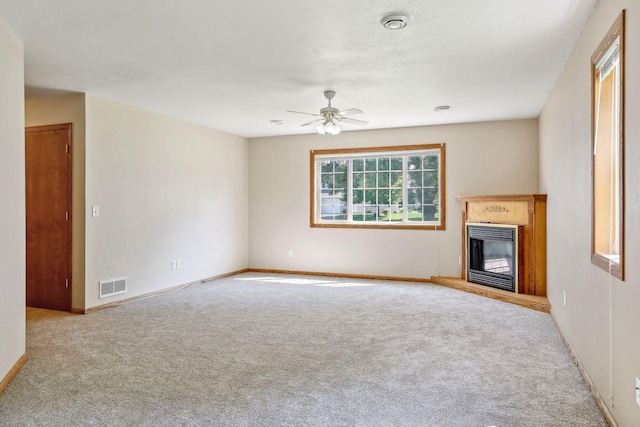 unfurnished living room with ceiling fan and light carpet