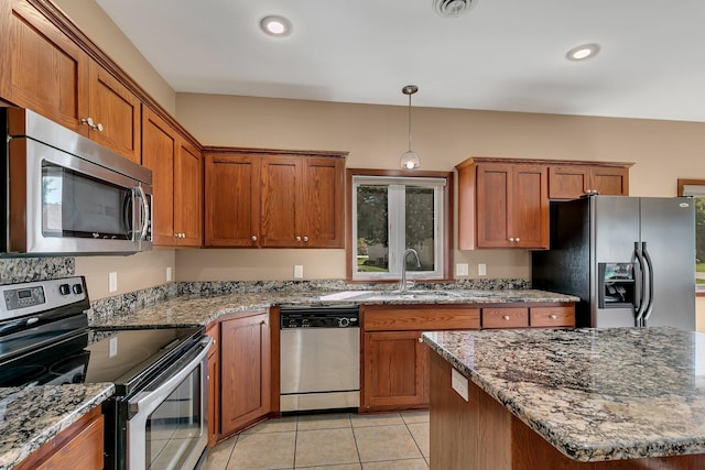 kitchen featuring hanging light fixtures, stone countertops, light tile patterned floors, and appliances with stainless steel finishes