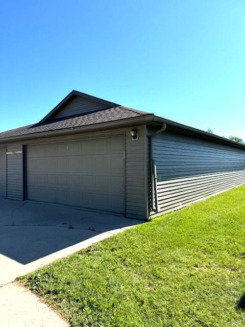 view of home's exterior with a garage and a yard