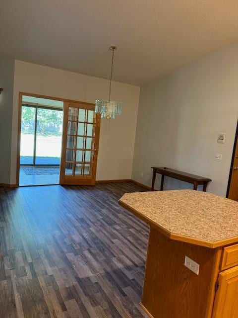 unfurnished dining area with dark wood-type flooring and a notable chandelier