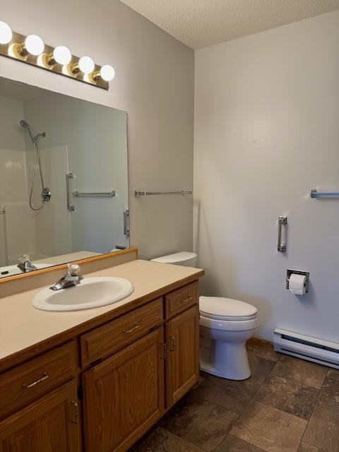 bathroom with baseboard heating, vanity, a textured ceiling, a shower, and toilet