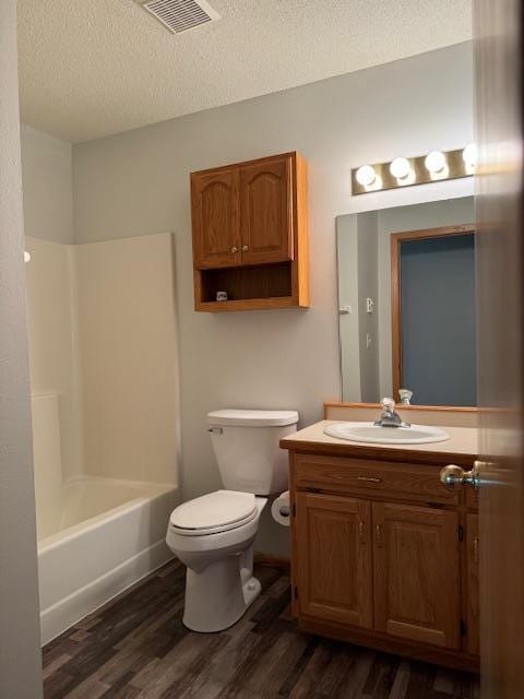 full bathroom featuring vanity, wood-type flooring, bathtub / shower combination, and a textured ceiling