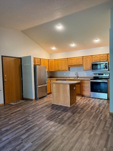 kitchen featuring sink, a textured ceiling, appliances with stainless steel finishes, dark hardwood / wood-style floors, and a kitchen island