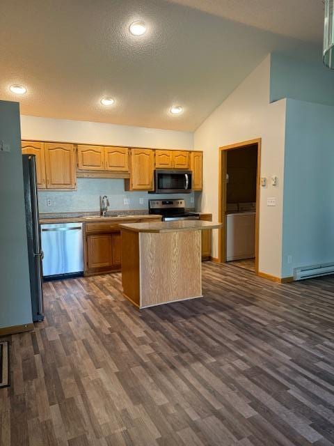 kitchen featuring dark wood-type flooring, lofted ceiling, appliances with stainless steel finishes, and a center island