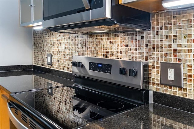 kitchen with dark stone countertops, stainless steel range with electric cooktop, and backsplash