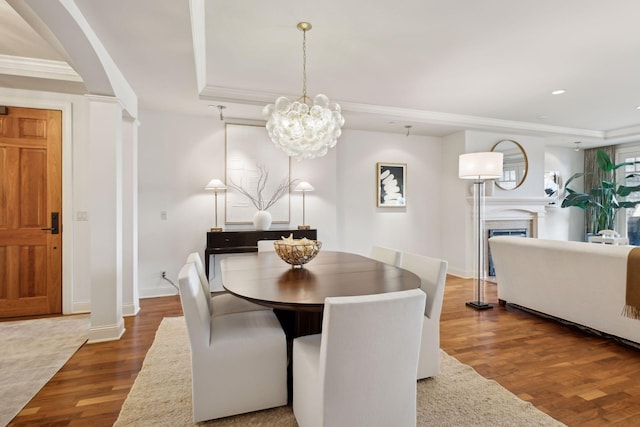 dining room with crown molding, dark hardwood / wood-style floors, and an inviting chandelier