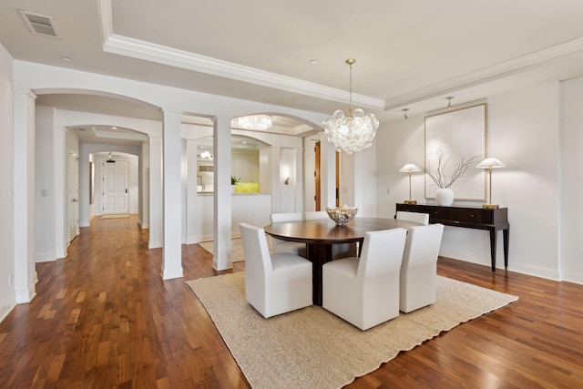 dining space featuring crown molding, dark wood-type flooring, and a tray ceiling