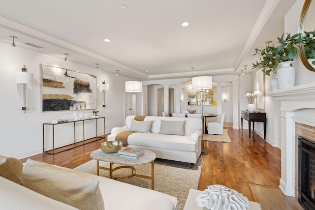 living room featuring crown molding, wood-type flooring, and a premium fireplace