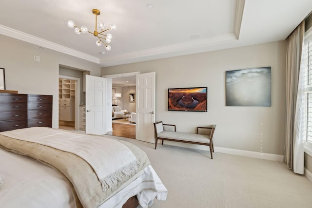 carpeted bedroom with ornamental molding, a spacious closet, a chandelier, and a closet