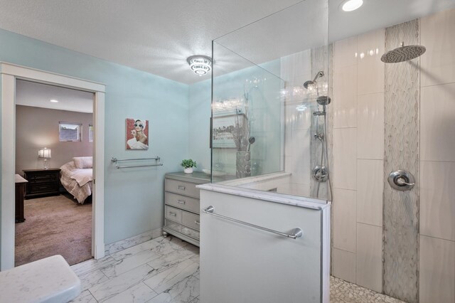 bathroom featuring a tile shower, a textured ceiling, and vanity