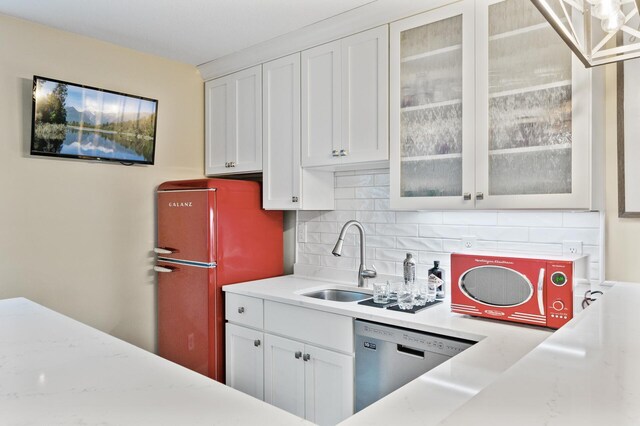 kitchen with decorative backsplash, white cabinetry, sink, and stainless steel appliances