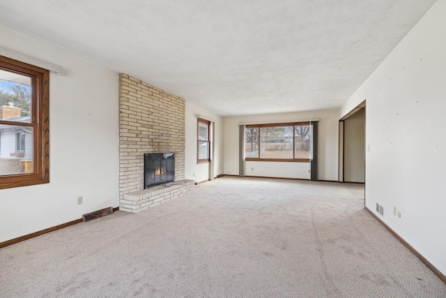 unfurnished living room with a fireplace, a textured ceiling, and carpet floors