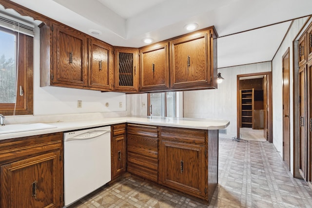 kitchen featuring dishwasher, kitchen peninsula, and sink