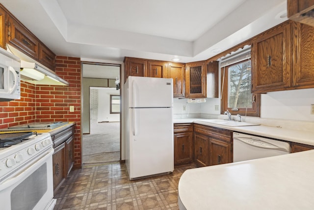 kitchen with dark carpet, white appliances, sink, and exhaust hood