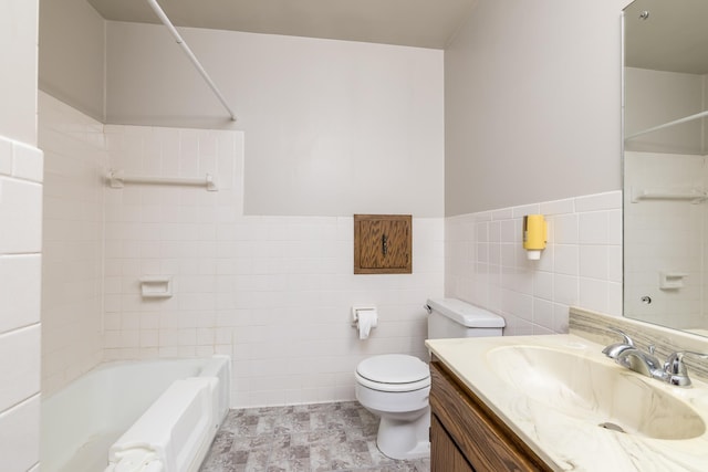 full bathroom with vanity, tiled shower / bath combo, tile walls, and toilet