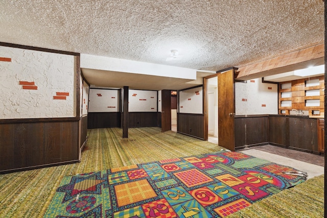 interior space featuring wood walls, light carpet, and a textured ceiling