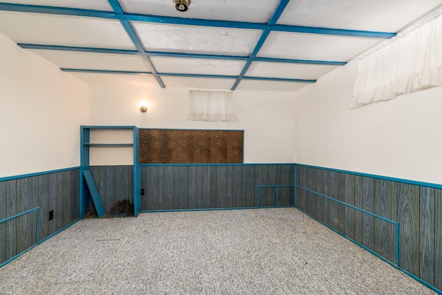 carpeted spare room featuring coffered ceiling