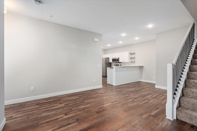 unfurnished living room with dark wood-type flooring