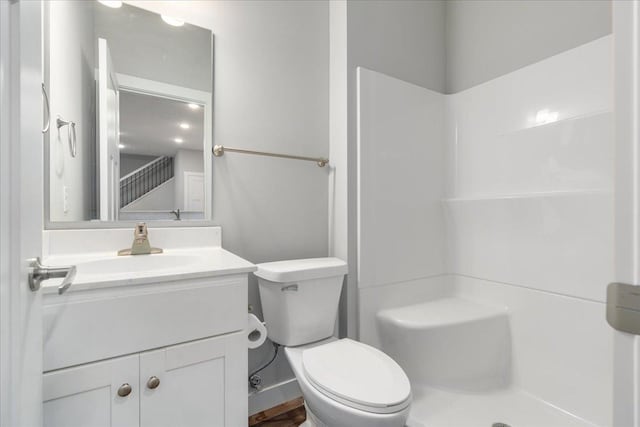 bathroom featuring walk in shower, vanity, and toilet