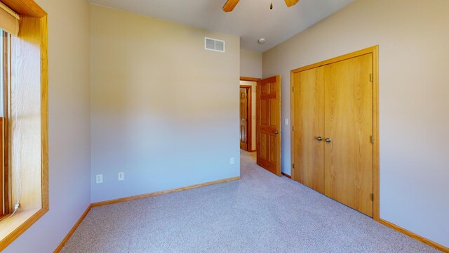 unfurnished bedroom featuring a closet, carpet, visible vents, and baseboards