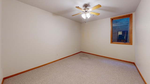 carpeted empty room with baseboards and a ceiling fan