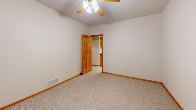 unfurnished room featuring light colored carpet, visible vents, ceiling fan, and baseboards