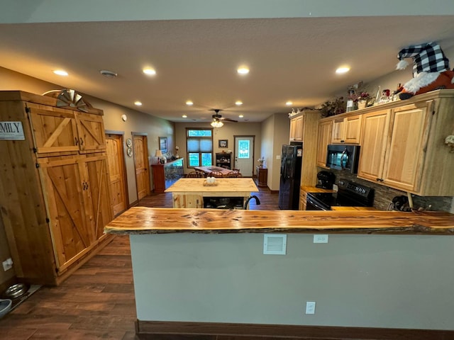 kitchen featuring butcher block countertops, recessed lighting, black appliances, and dark wood-style flooring