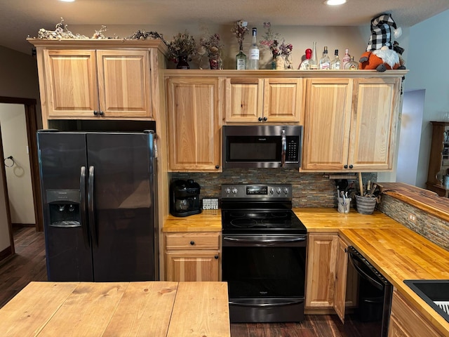 kitchen featuring decorative backsplash, dark wood-type flooring, black appliances, and butcher block counters