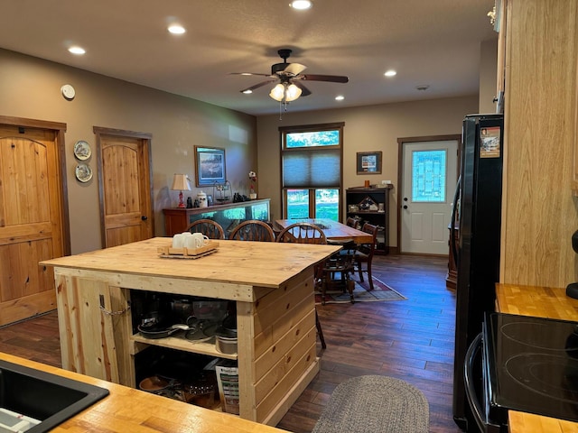 kitchen with recessed lighting, freestanding refrigerator, ceiling fan, butcher block countertops, and dark wood-type flooring