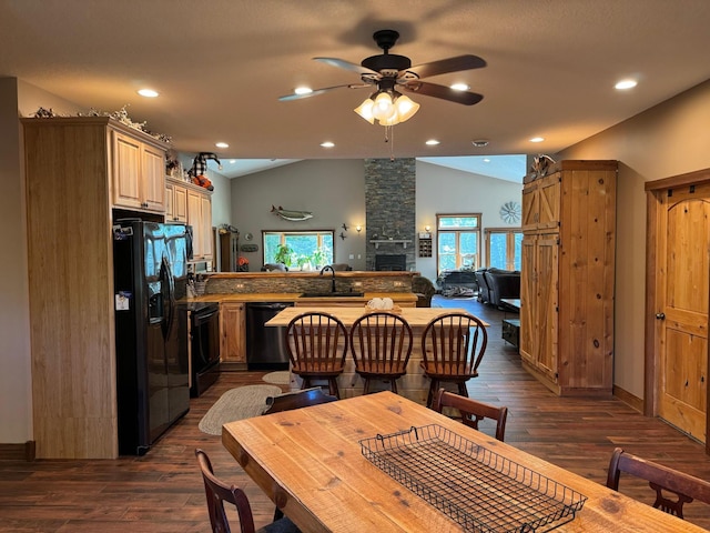 dining area featuring vaulted ceiling, dark wood-style floors, recessed lighting, and a fireplace