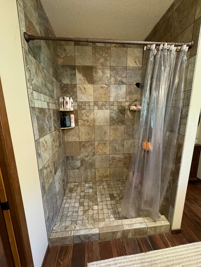 full bath with a stall shower and a textured ceiling