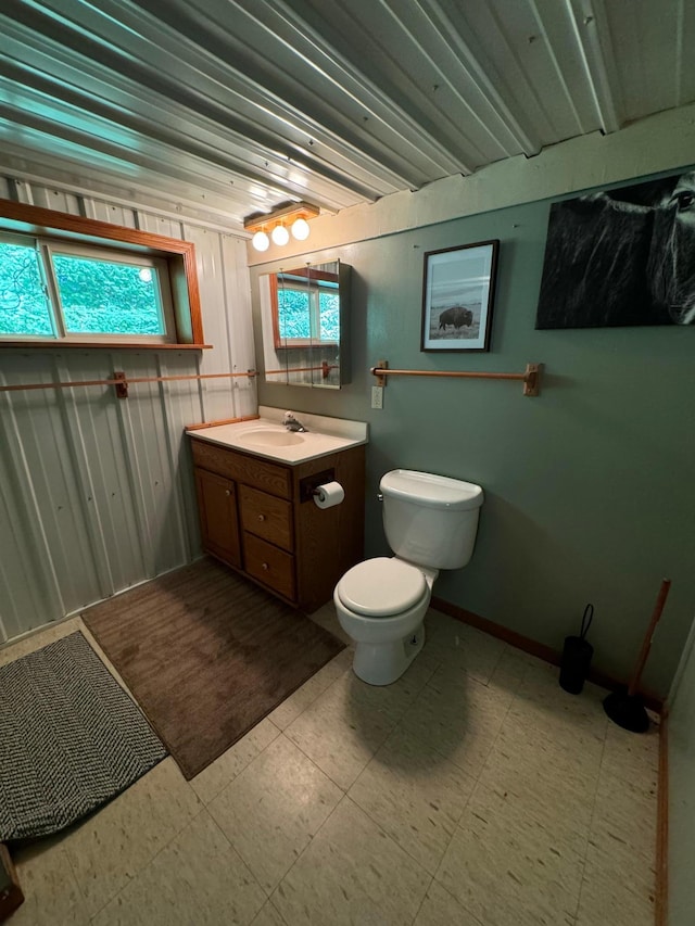 bathroom featuring tile patterned floors, baseboards, toilet, and vanity