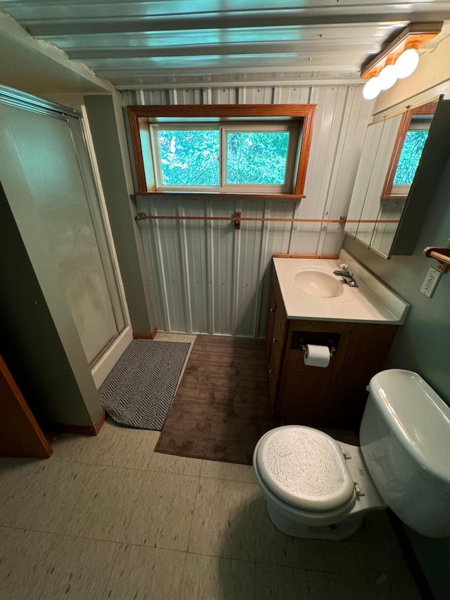 bathroom with vanity, tile patterned floors, toilet, and a stall shower