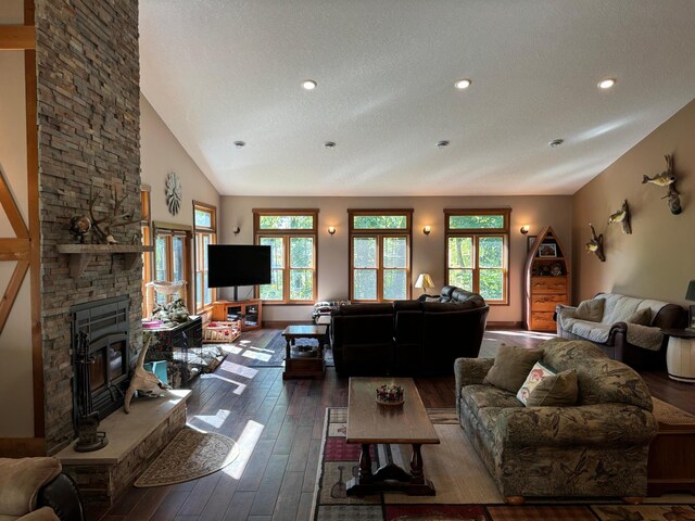 living area featuring hardwood / wood-style floors, vaulted ceiling, baseboards, and a textured ceiling