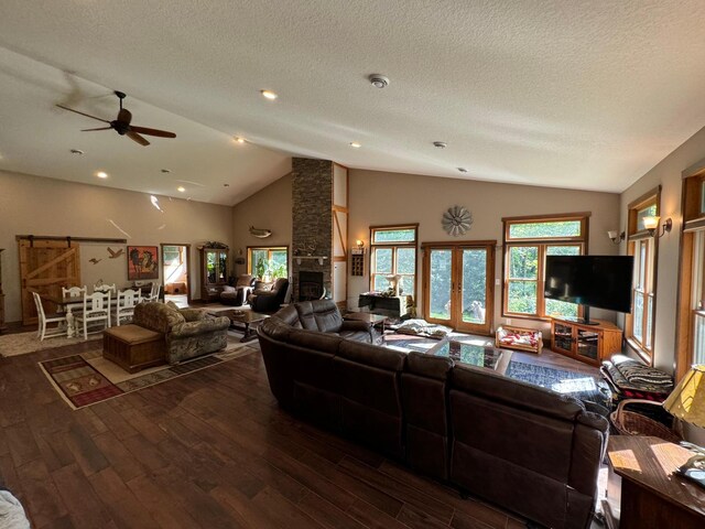 living area with hardwood / wood-style floors, a textured ceiling, french doors, and a fireplace