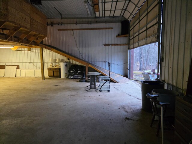 garage featuring metal wall and electric water heater