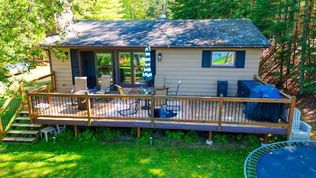 rear view of house featuring a deck, outdoor dining space, and a shingled roof