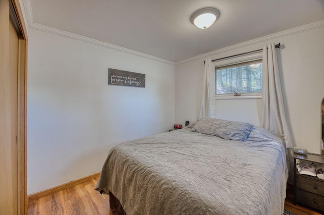 bedroom featuring crown molding and wood finished floors