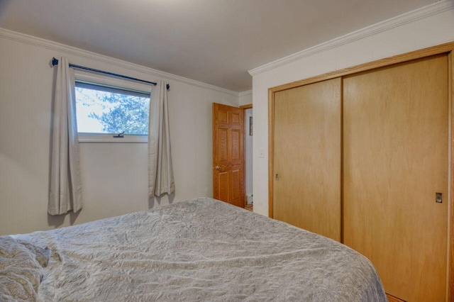 bedroom featuring crown molding and a closet