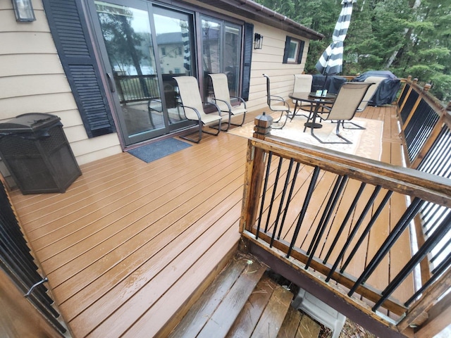 wooden terrace featuring outdoor dining space and a grill