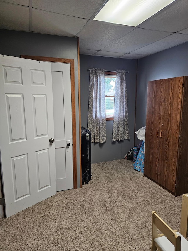 carpeted bedroom featuring a paneled ceiling