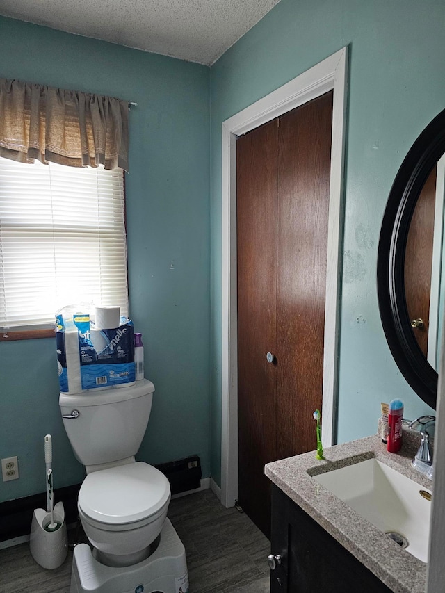 bathroom with vanity, wood-type flooring, a textured ceiling, and toilet