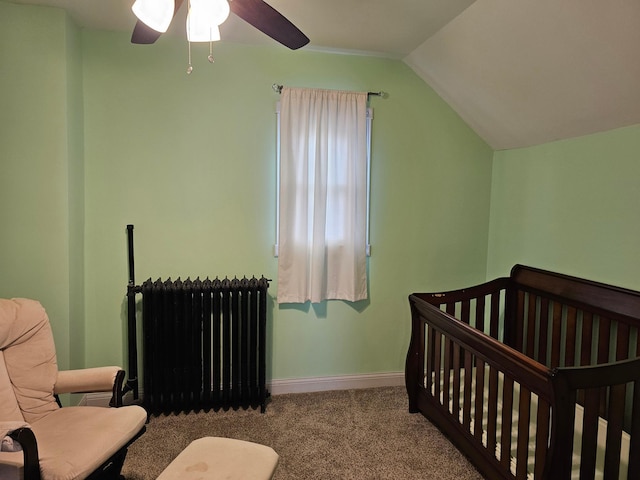 bedroom with lofted ceiling, radiator, carpet flooring, ceiling fan, and a nursery area