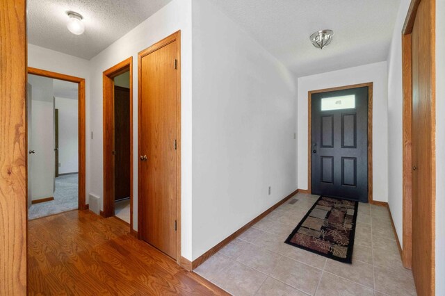 entryway with light hardwood / wood-style flooring and a textured ceiling