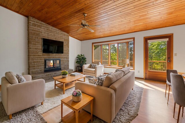 living room with light hardwood / wood-style flooring, lofted ceiling, and a healthy amount of sunlight