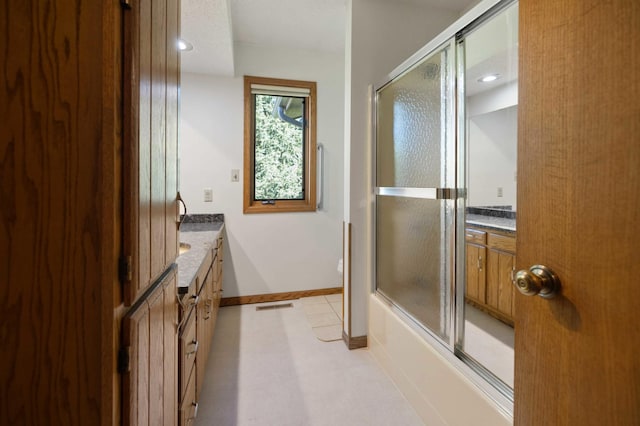 bathroom with shower / bath combination with glass door and vanity