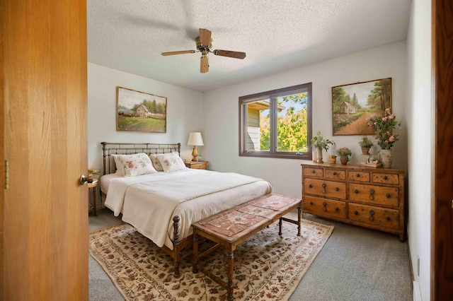 bedroom with a textured ceiling, carpet flooring, and ceiling fan