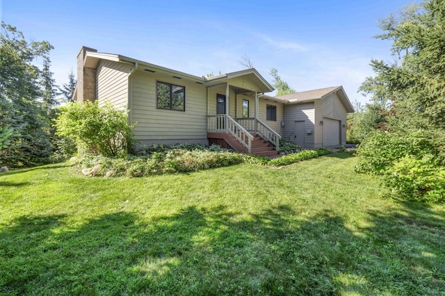 rear view of house with a garage and a yard