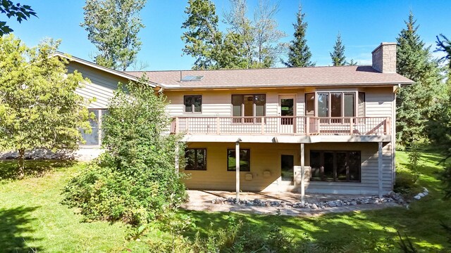 rear view of house with a patio, a yard, and a deck