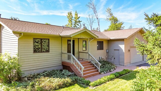 ranch-style home featuring a garage and a front lawn